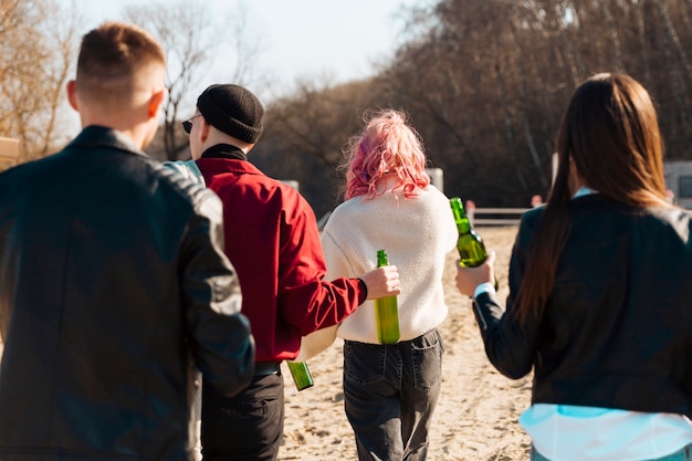 Free photo group of people walking with beer bottles