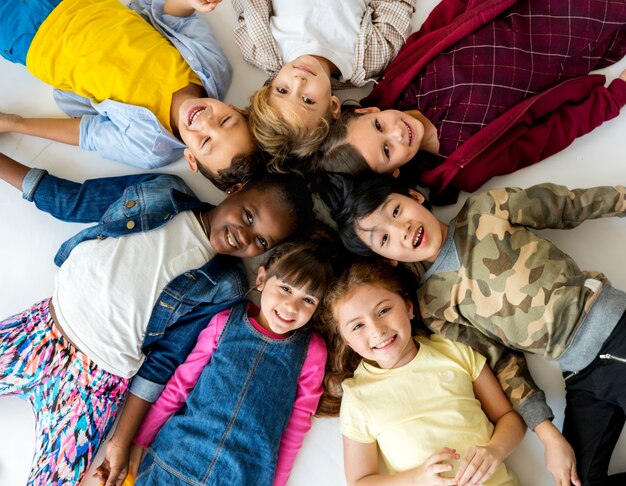 A group of primary schoolers lying on the ground and smiling