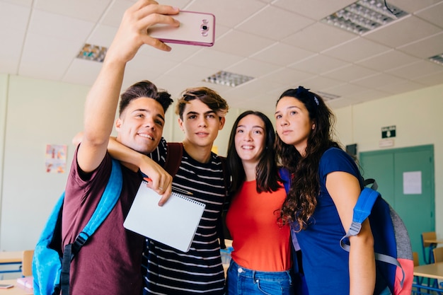 Group of schoolkids taking a selfie in classroom