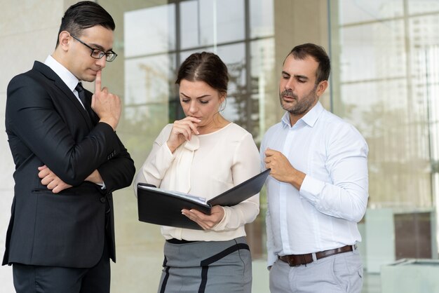 Group of serious business people reading document