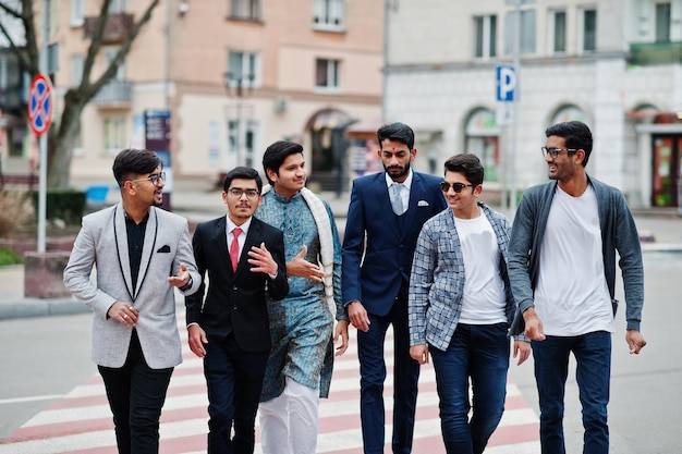 Group of six south asian indian mans in traditional casual and business wear walking at crosswalk together