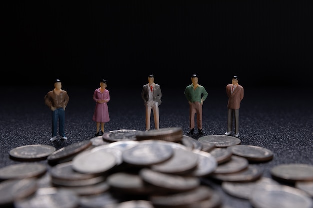 Free Photo group of small businessmen standing on coins