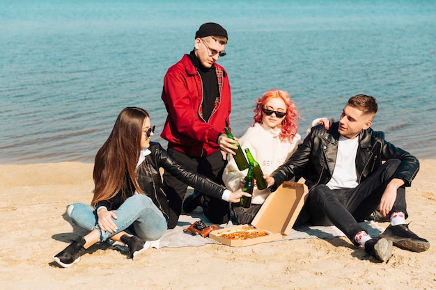 Group of smiling friends on picnic at beach