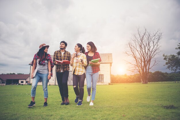 Group of student walking through the park after class. Enjoy talking together.