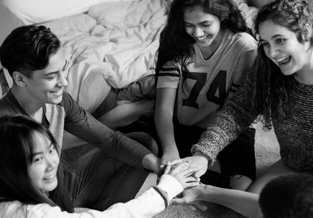 Group of teenagers in a bedroom putting their hands together community and temwork concept