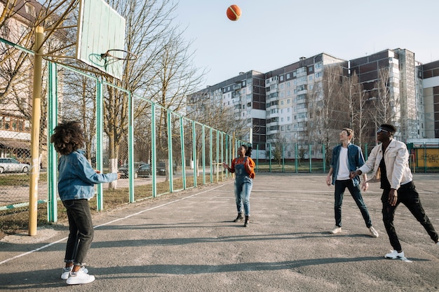 Group of teenagers playing basketball together