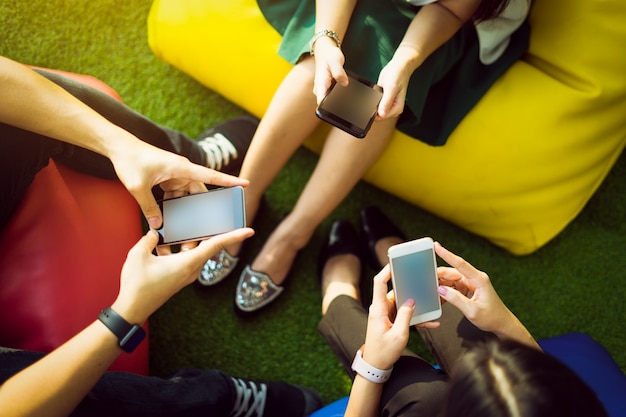 Free Photo group of three young people using smartphones together, modern lifestyle or communication technology gadget concept.