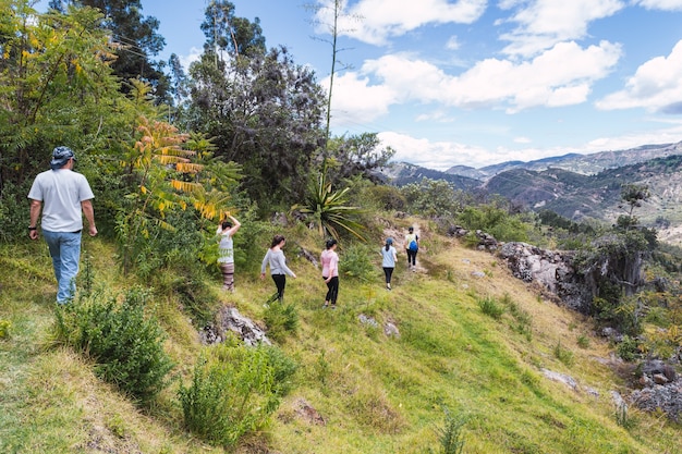 Group of tourists walking through a narrow path on the mountain