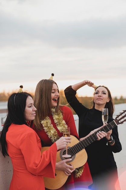 Group of women playing the guitar on the rooftop party