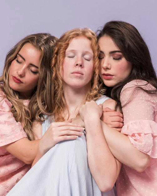 Group of women posing while hugging each other as a sign on unity