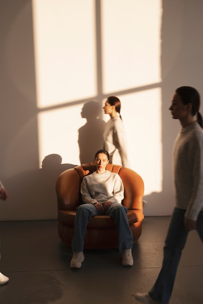 Free photo group of women in sweaters and jeans posing for minimalistic portraits in window shadow