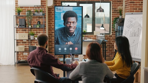 Free photo group of workers using remote video call to talk to man about business growth on computer. team of people meeting to discuss marketing collaboration on online internet teleconference.