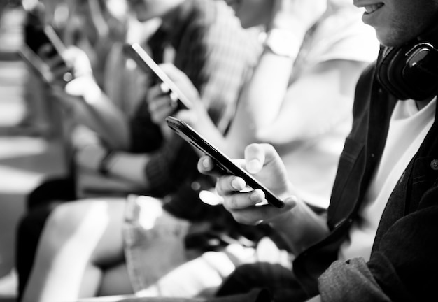 Free photo group of young adult friends using smartphones in the subway