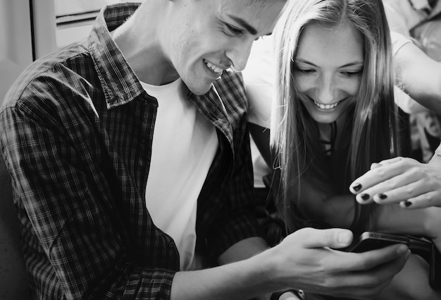 Free photo group of young adult friends using smartphones in the subway