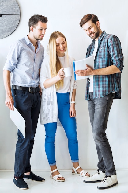 Group of young businesspeople looking at document in office