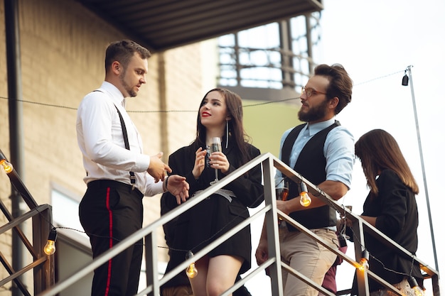 Group of young caucasian people celebrating, look happy, have corporate party at office or bar