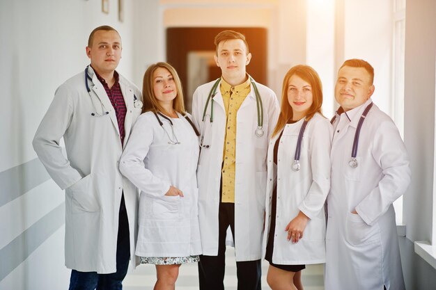 Group of young doctors in white coats posing in the hospital