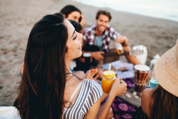 Group of young friends sitting at the beach