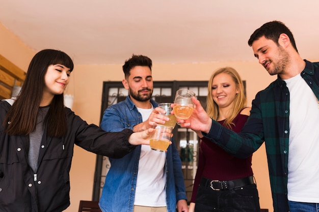 Free photo group of young happy friends toasting with glass of alcohol