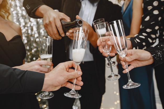 Group of young people celebrating new year. Friends drinks champagne.