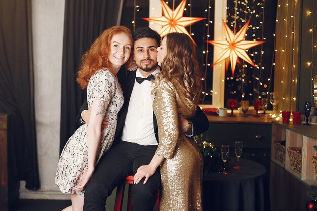 Group of young people celebrating new year. Women with indian man.