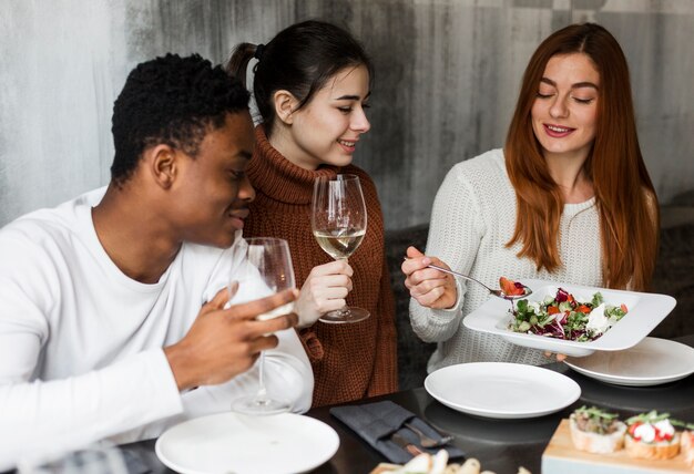 Group of young people enjoying dinner together