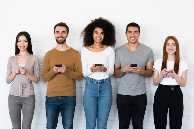 Free photo group of young people holding their mobile phones