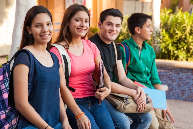 Groupo of four teenage friends hanging out in high school