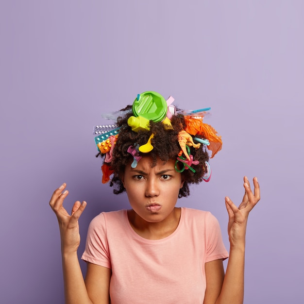 Free photo grumpy outraged woman posing with garbage in her hair