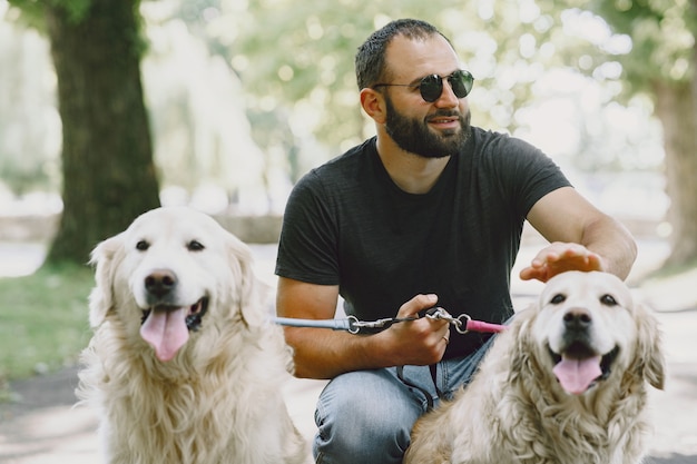 Guide dog helping blind man in the city. Handsome blind guy have rest with golden retriever in the city.