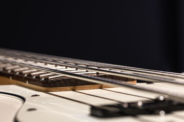 Guitar bass string details, close up of the iron strings on black background copy space.