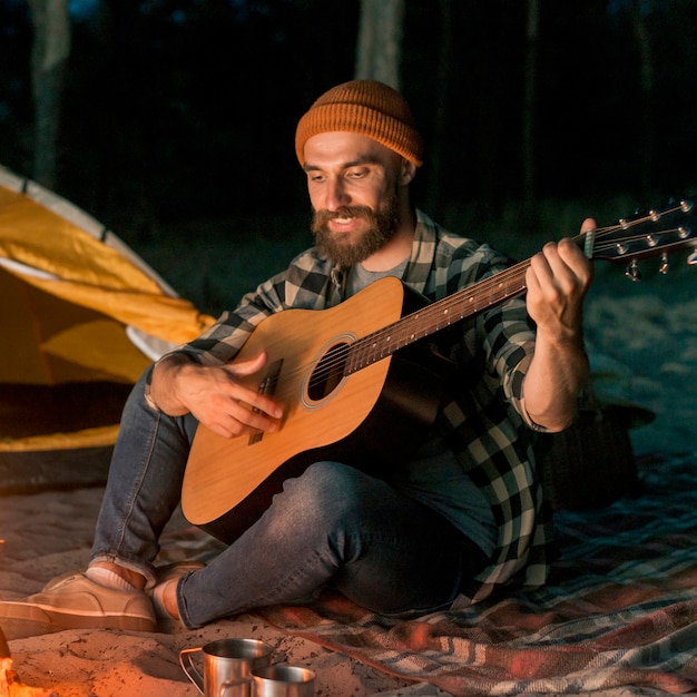 Free Photo guitarist camping and singing by a bonfire