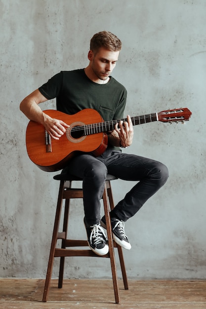 Guitarist man playing guitar at home