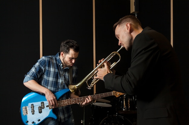 Free Photo guitarist and trumpet player performing