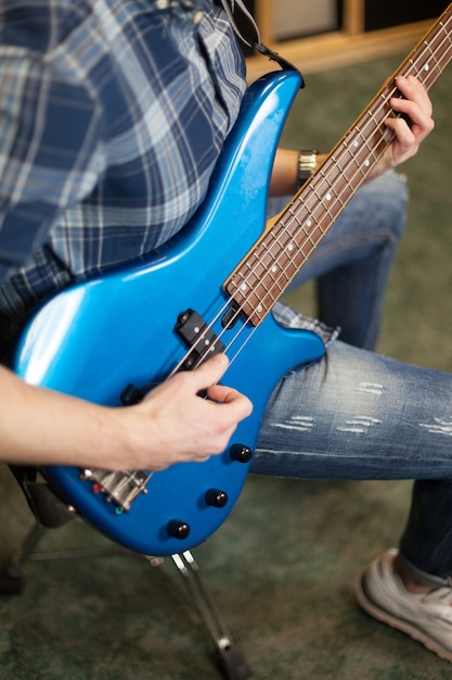 Free photo guitarist with blue guitar side view