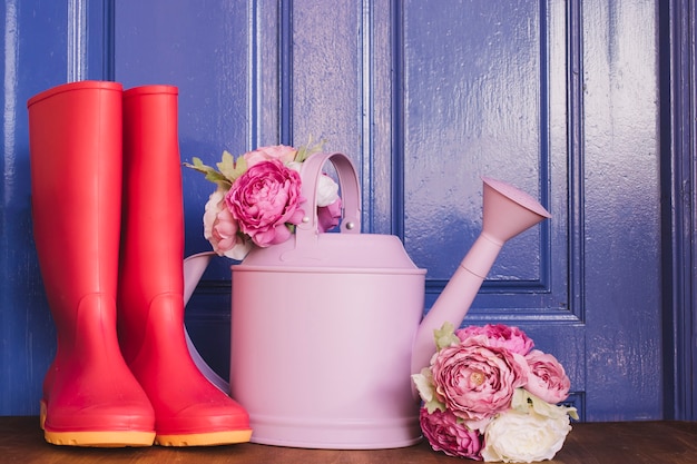 Gumboots, watering can and roses