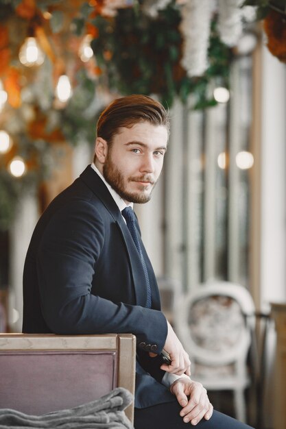 Guy in a black suit. Male at the restaurant.