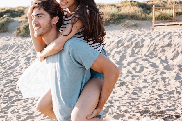 Free photo guy carrying girl at the beach