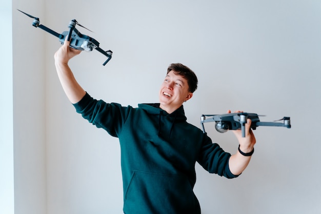 Guy holds two quadrocopters against a wall