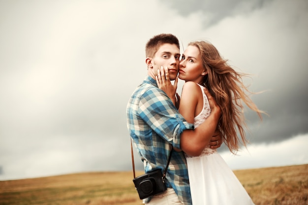 Free photo guy hugging his girlfriend on a cloudy day