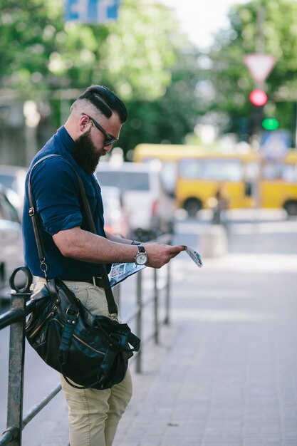 Guy looking for something on the map with city background