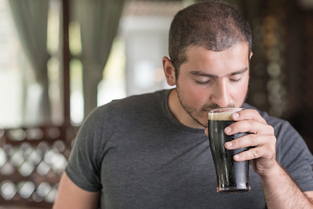 Guy smelling beer in pub