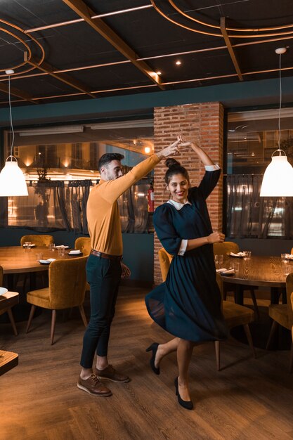 Guy whirling cheerful lady in restaurant