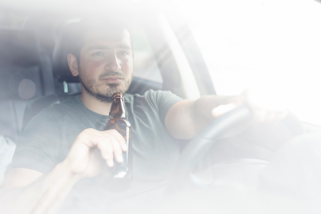 Free photo guy with booze driving car