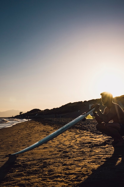 Free photo guy with surfboard at the beach