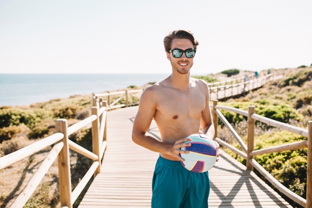 Free photo guy with volleyball at the beach