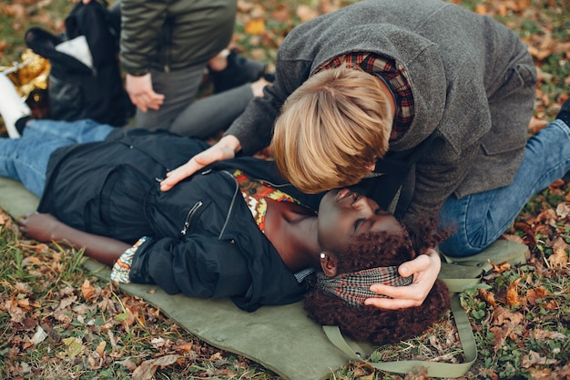 Free Photo guys help a woman. african girl is lying unconscious. providing first aid in the park.