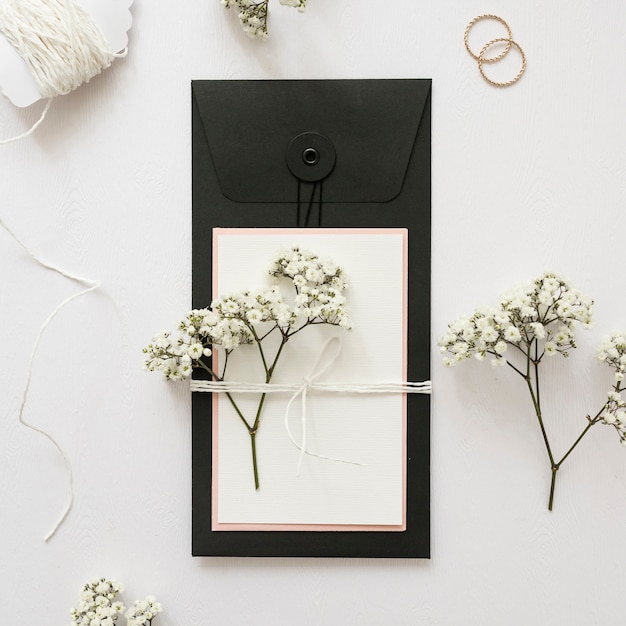 Free Photo gypsophila and greeting card tied with strings on white backdrop