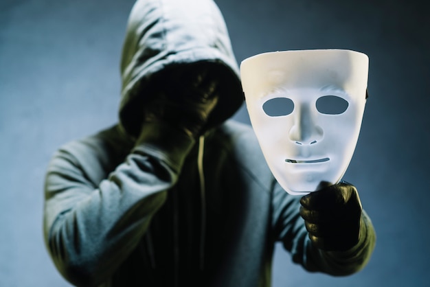 Hacker holding mask