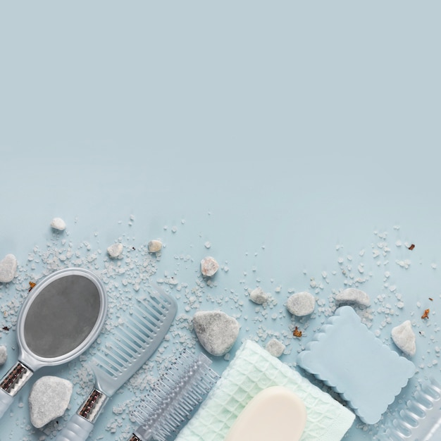 Free Photo hair comb; napkin; soap; sponge and hand mirror with spa stone and salt over blue background